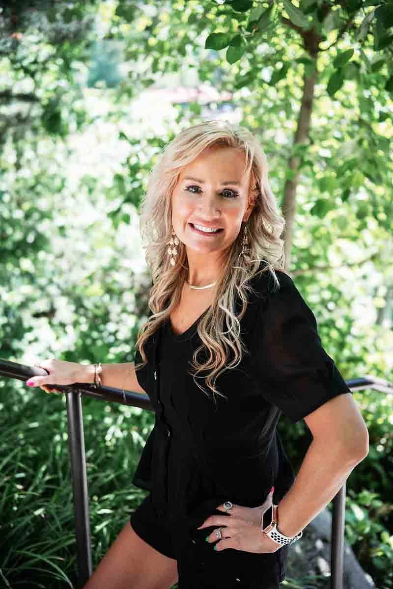 A Salon Sister smiling outdoors on a railing