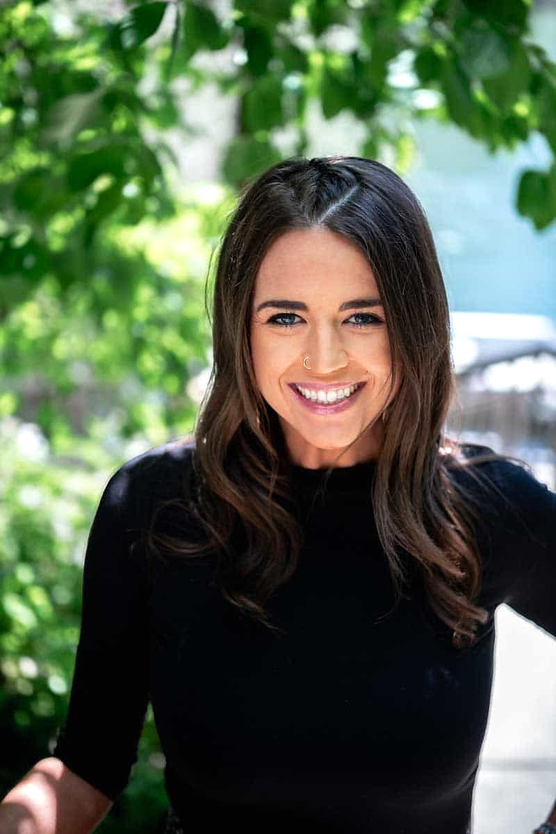 A Salon Sister with brunette hair smiling outdoors
